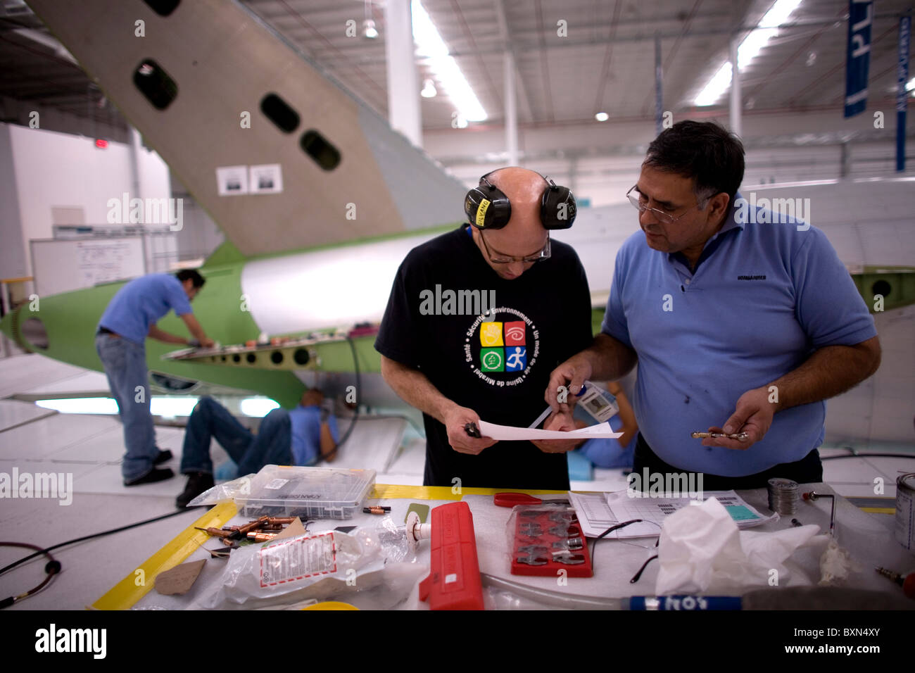 Workers build part of the structure of a plane in a Bombardier
