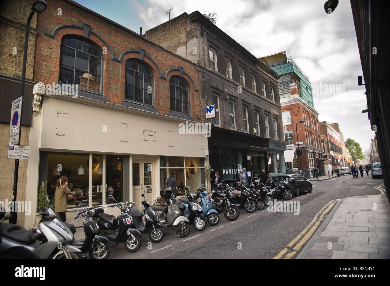 Motorcycles and scooters parked outside 'Caravan' in Redchurch Street, Shoreditch, London, UK