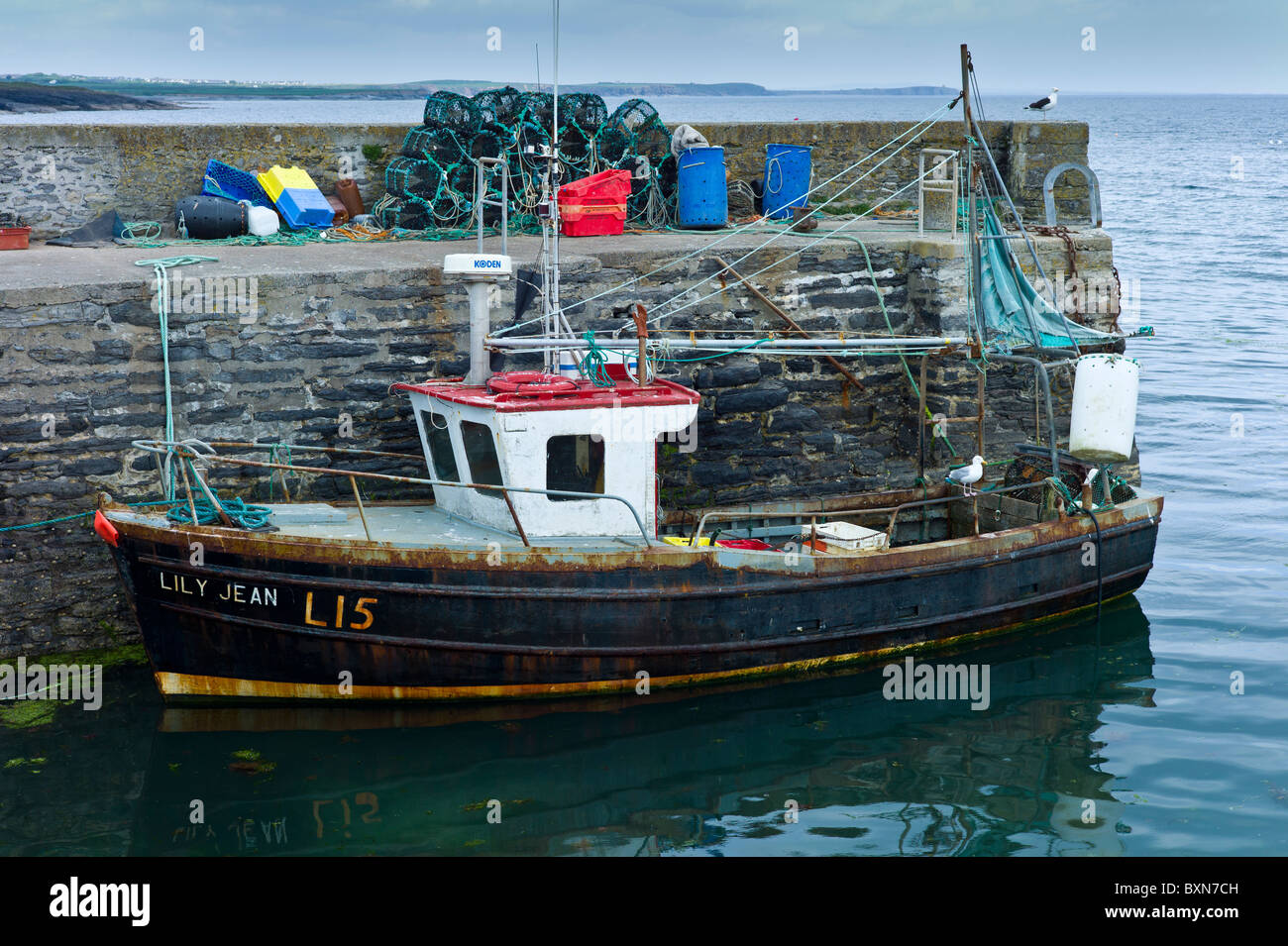 Fishing trawler boat by lobster pots at Slade Harbour, County Wexford, Southern Ireland Stock Photo