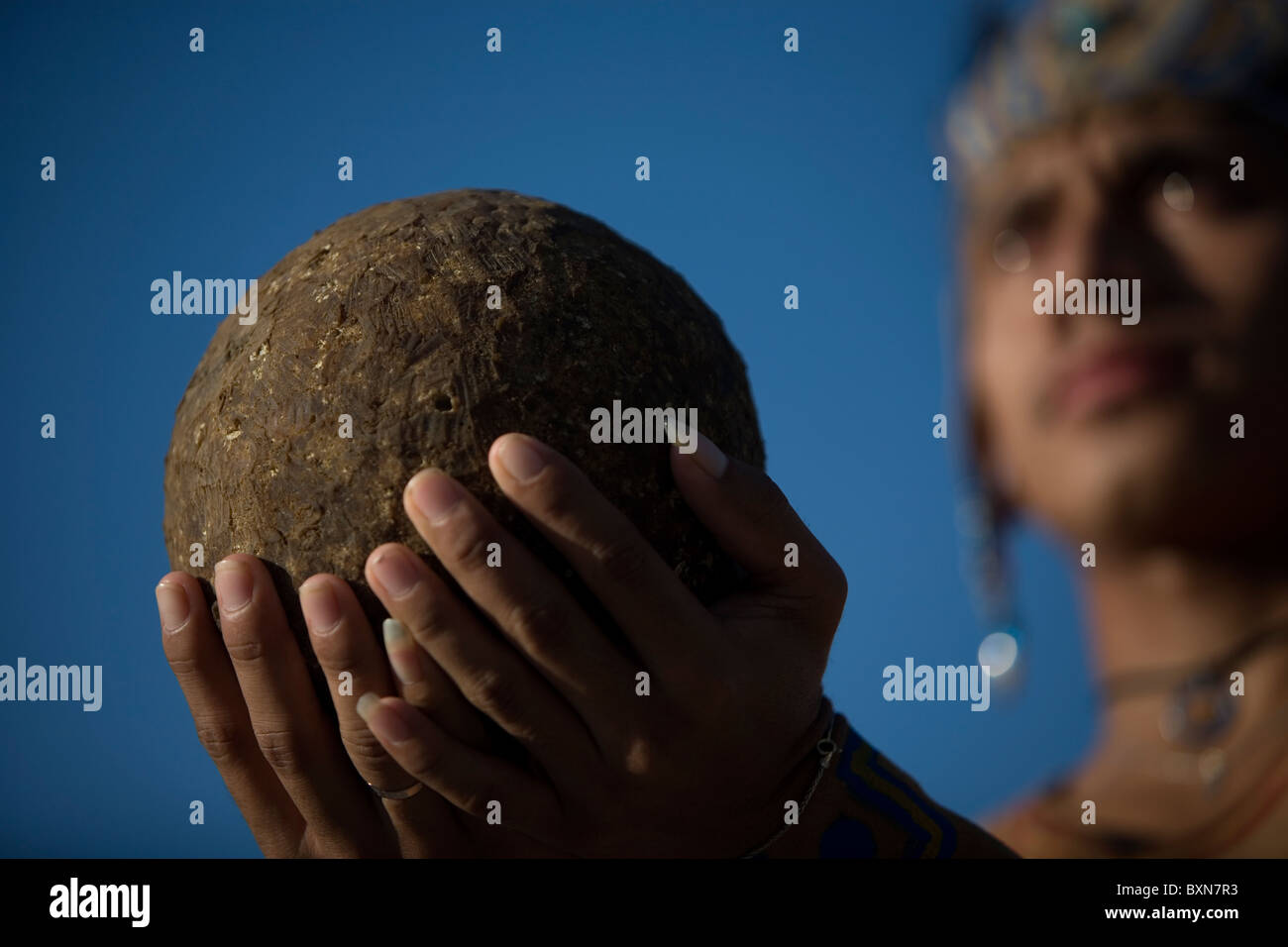 A Mayan ball player holds up the ball made of hule, natural rubber, in