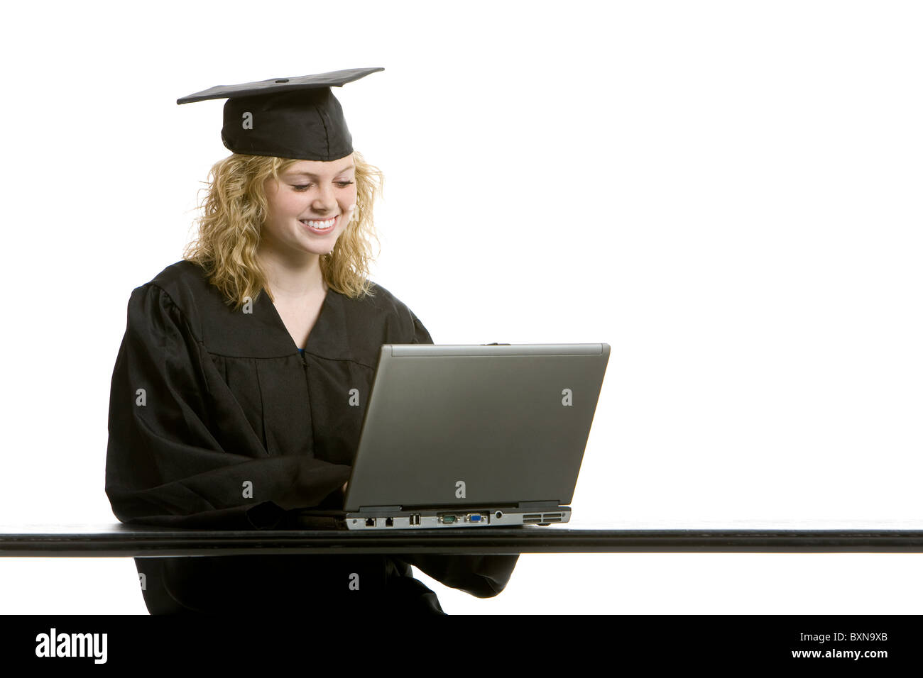 Young graduation girl on computer with white background Stock Photo