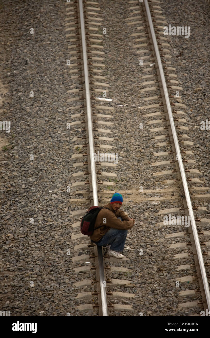 A migrant traveling across Mexico to work in the United States waits to jump a train in Mexico City, Mexico Stock Photo