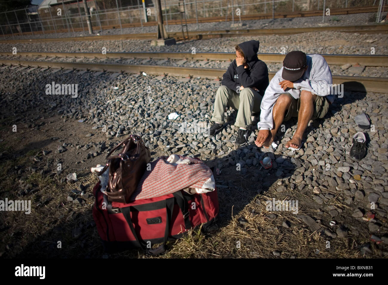 Central American migrants traveling across Mexico to work in the United States wait along the railroad tracks in Mexico City Stock Photo