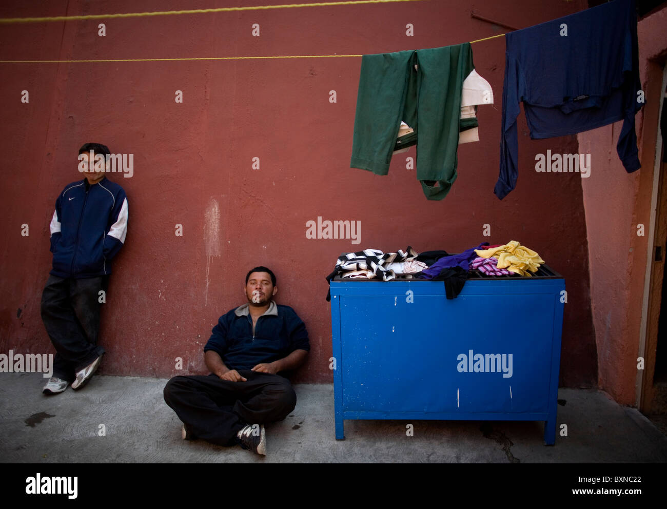 Central American migrants traveling across Mexico to work in the United States sit in a shelter in Mexico City Stock Photo