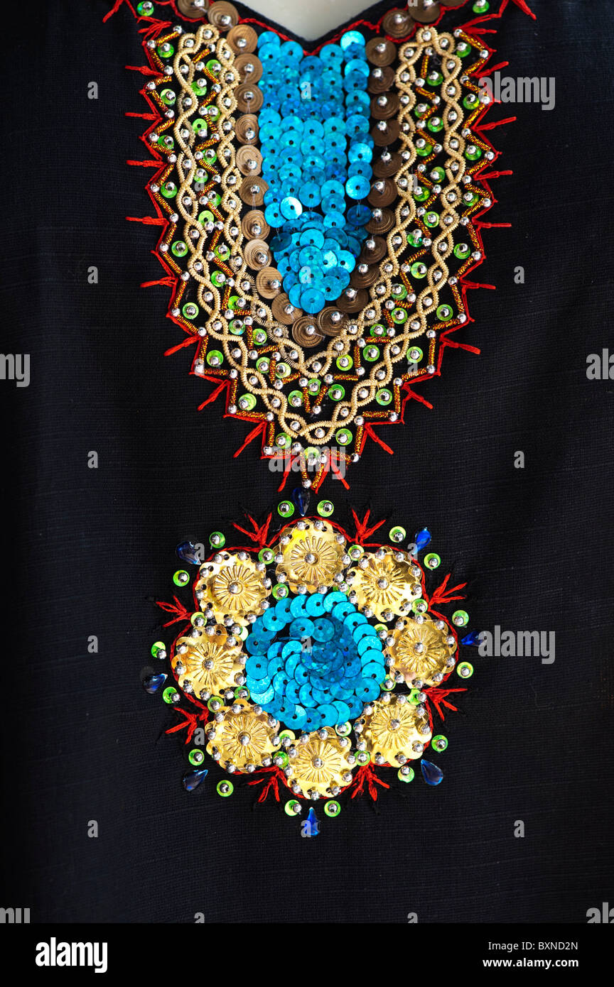 Embroidered indian fabric with gold / blue sequins on black. India Stock Photo