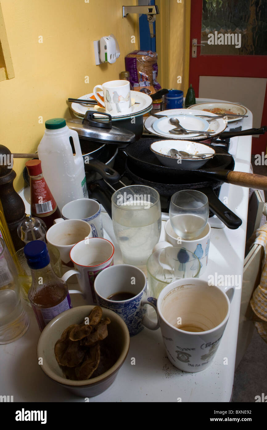 Piled up dirty cups, glasses, bowls, plates, dishes on a kitchen