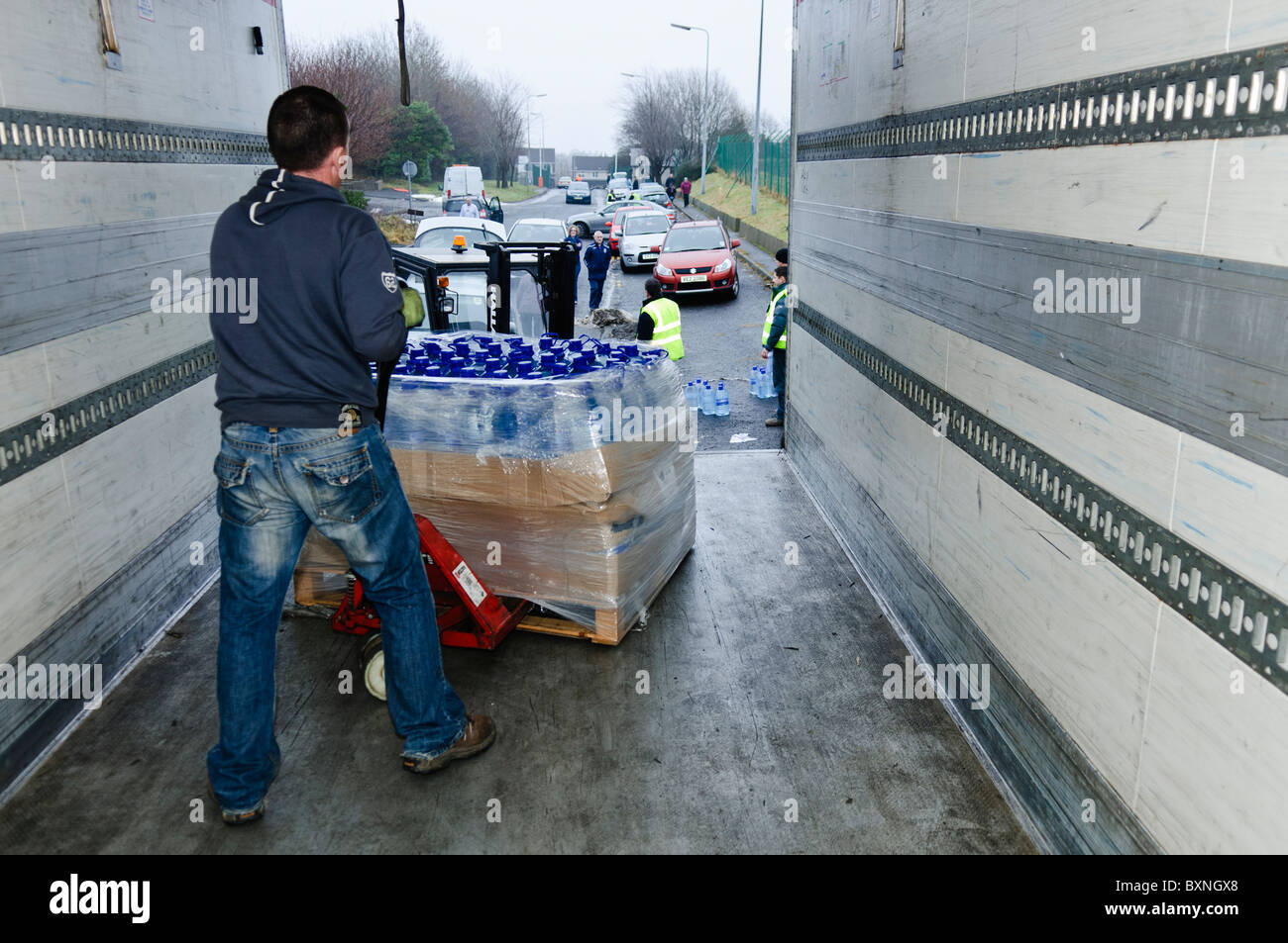 Offloading bottled water from a lorry using a forklift Stock Photo