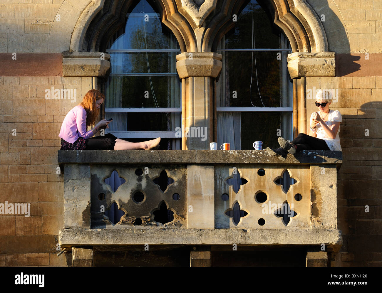Students sitting on the balcony of Oxford's Christ Church College Stock Photo