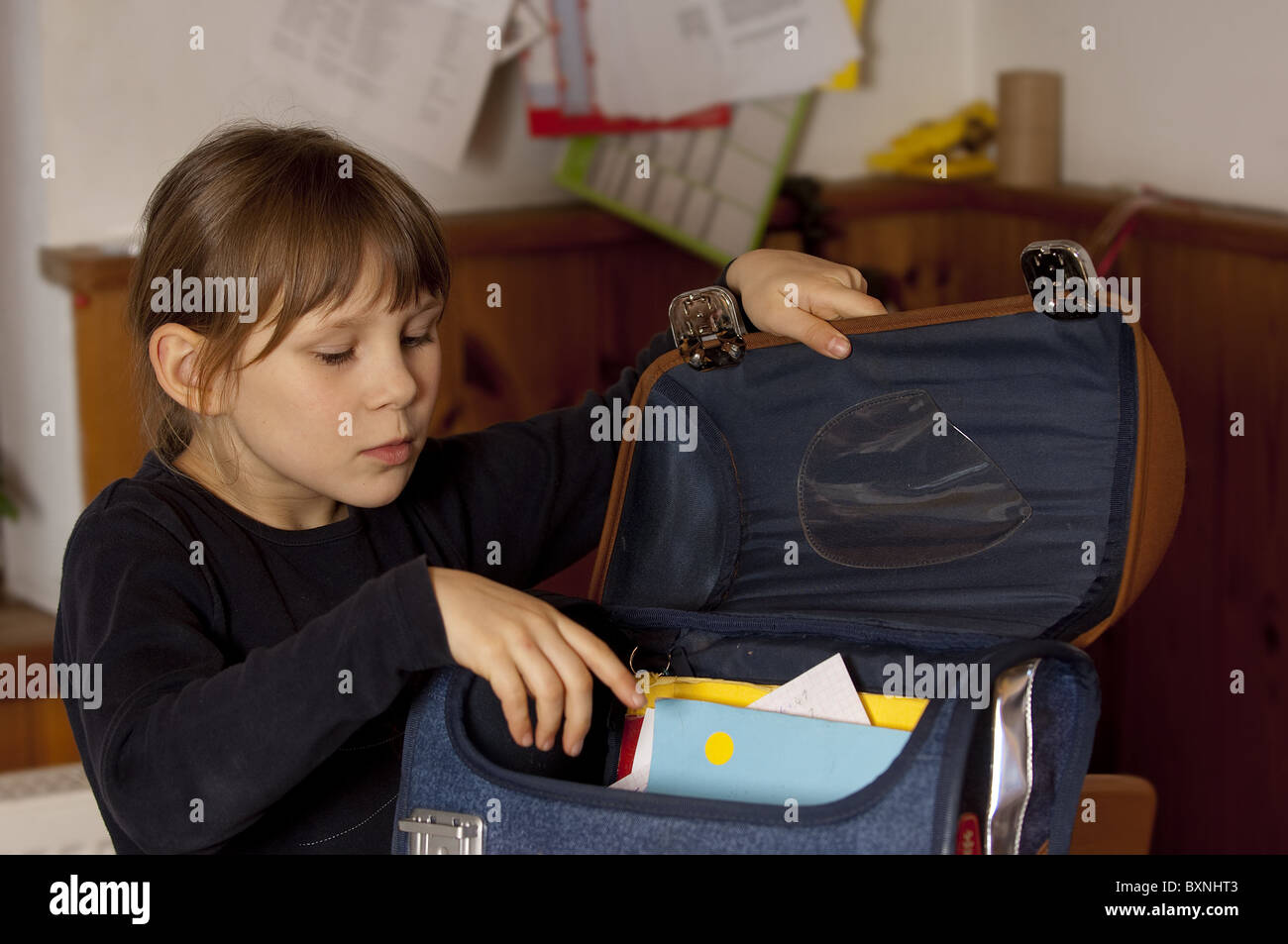 Schoolgirl packing satchel Stock Photo