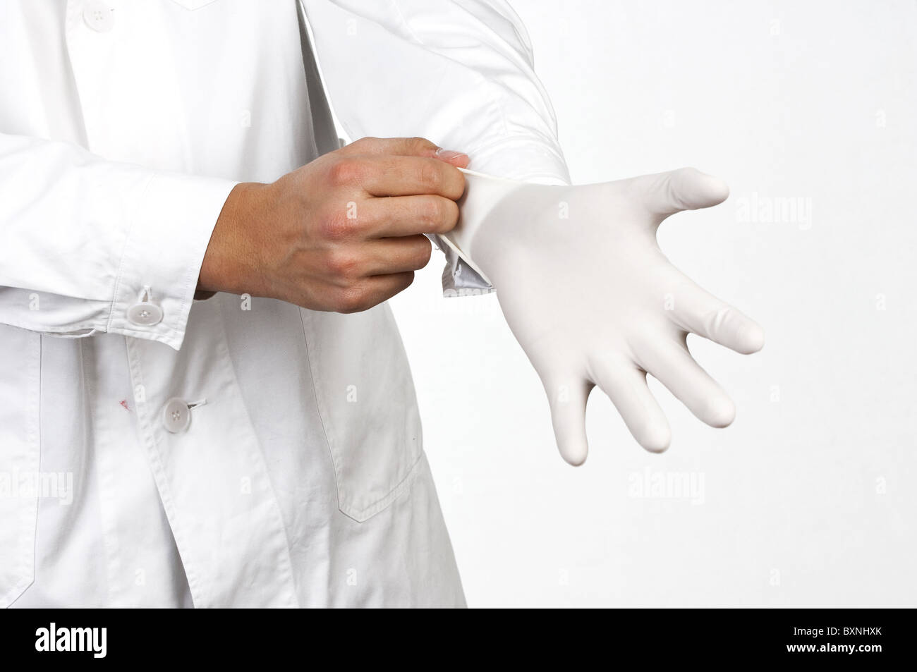 Doctor putting on latex gloves Stock Photo