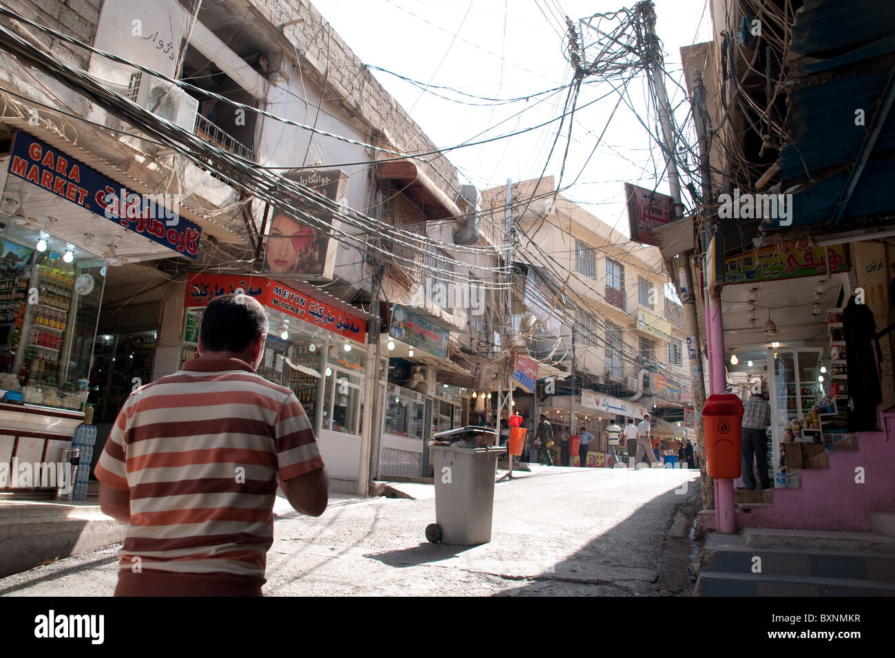 A Kurdish man walking through a pedestrian alleyway in the outdoor bazaar in the city of Duhok, in the Kurdistan region, of Northern Iraq. Stock Photo