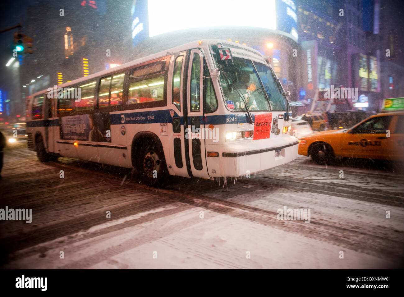 An NYC Transit bus travels through the snow in Times Square in New York