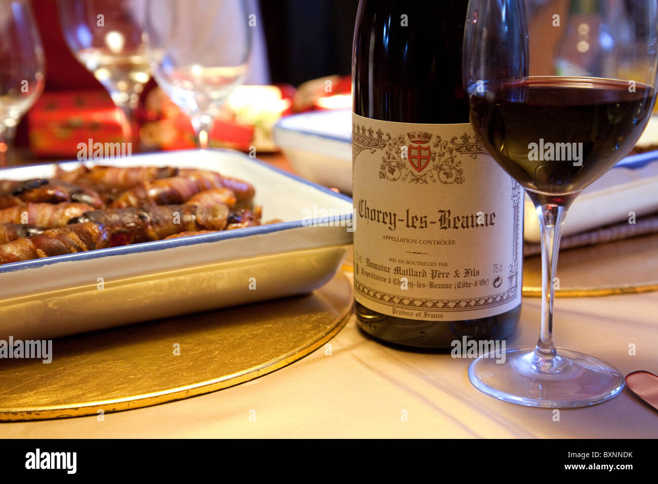 Red burgundy wine and sausages on the dinner table on Christmas day, UK Stock Photo