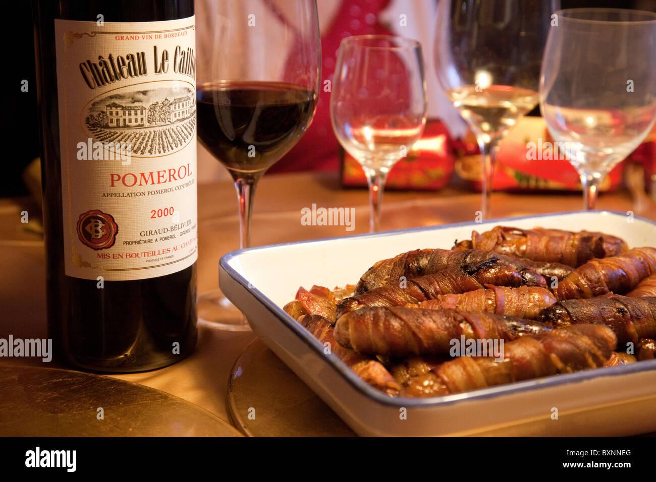 Food and wine - Claret and sausages wrapped in bacon on the Christmas dinner table, UK Stock Photo