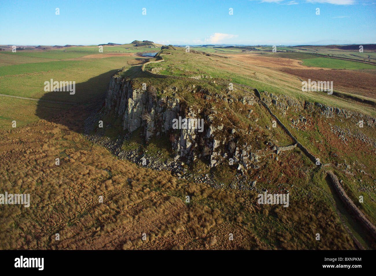 Hadrian's wall running over Peel Crags with Highshield Crags and Crag Lough in background Stock Photo
