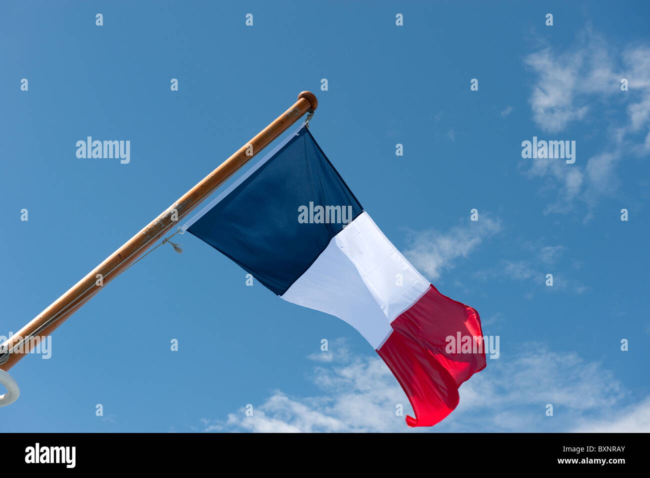 French Flag Flying against Blue Sky Stock Photo