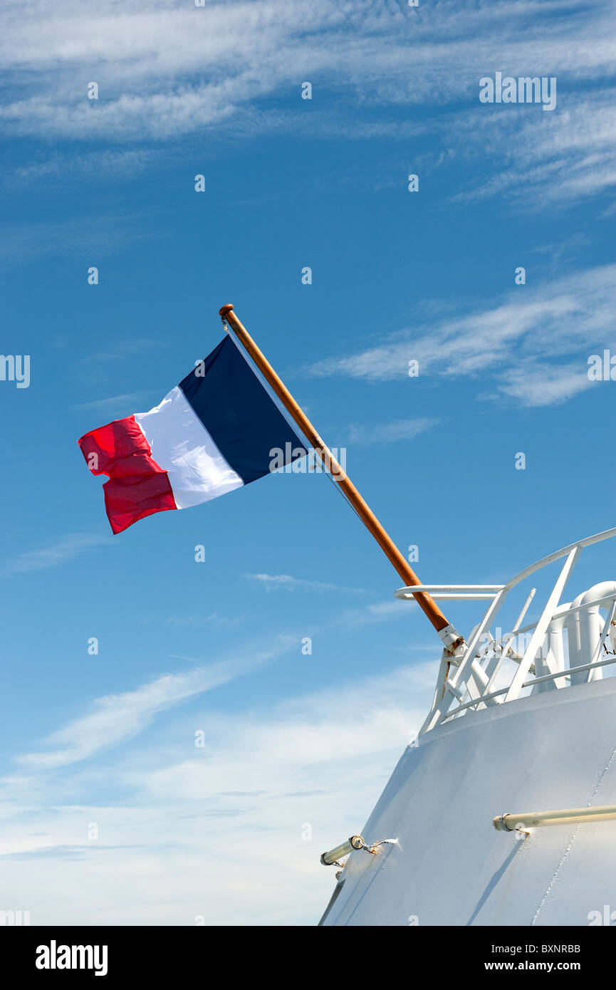 French Flag Flying on Ship against Blue Sky Stock Photo