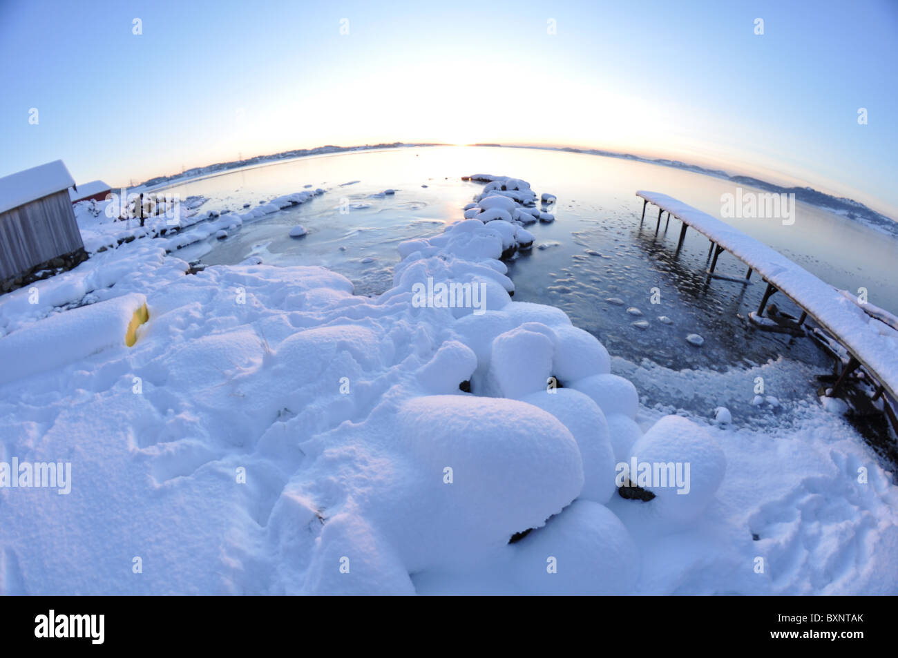 Winter landscape by the sea seen through a fisheye lense. snow, sea, pier Stock Photo