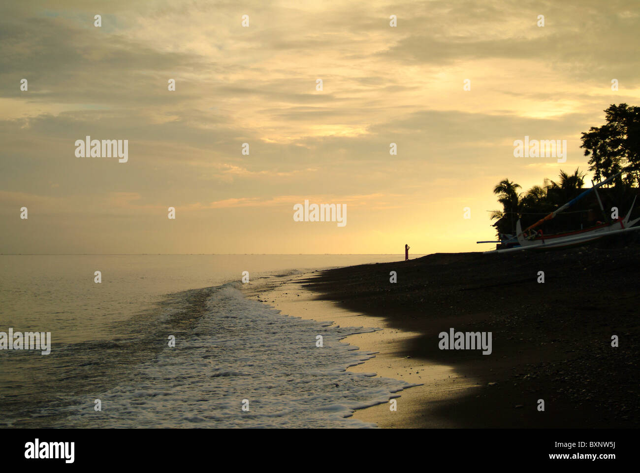 Sunset in Amed, Bali, Indonesia on a beautiful sandy beach. Amed is in east bali and is a fishing village just open to tourism. Stock Photo