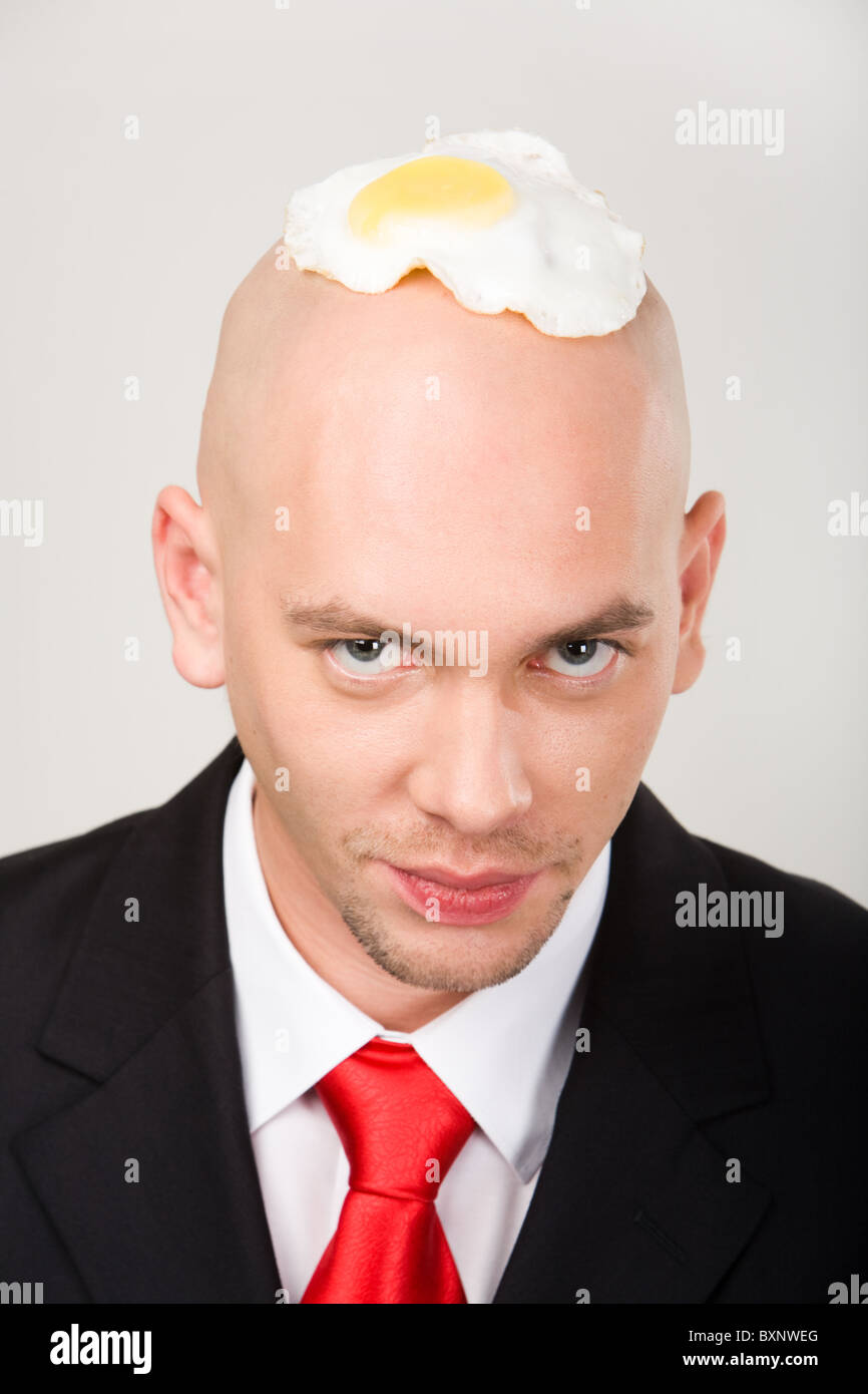 bald-man-with-fried-eggs-on-top-of-head-looking-at-camera-BXNWEG.jpg