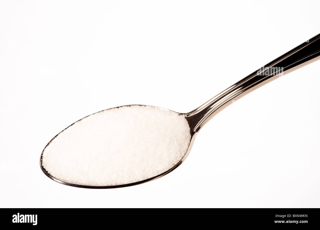 Teaspoon of salt or sugar against a white background suitable for