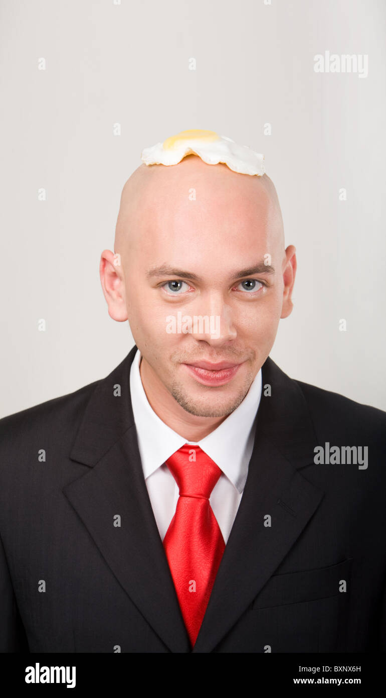 Portrait of smiling male with omelet on top of bald head Stock