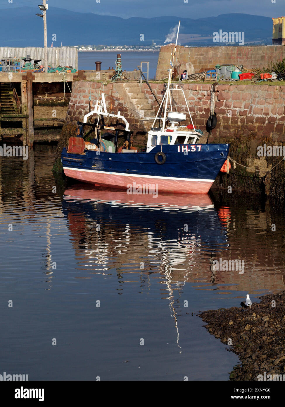 Fishing boat reflections at low tide in Cromarty Harbour, Scotland