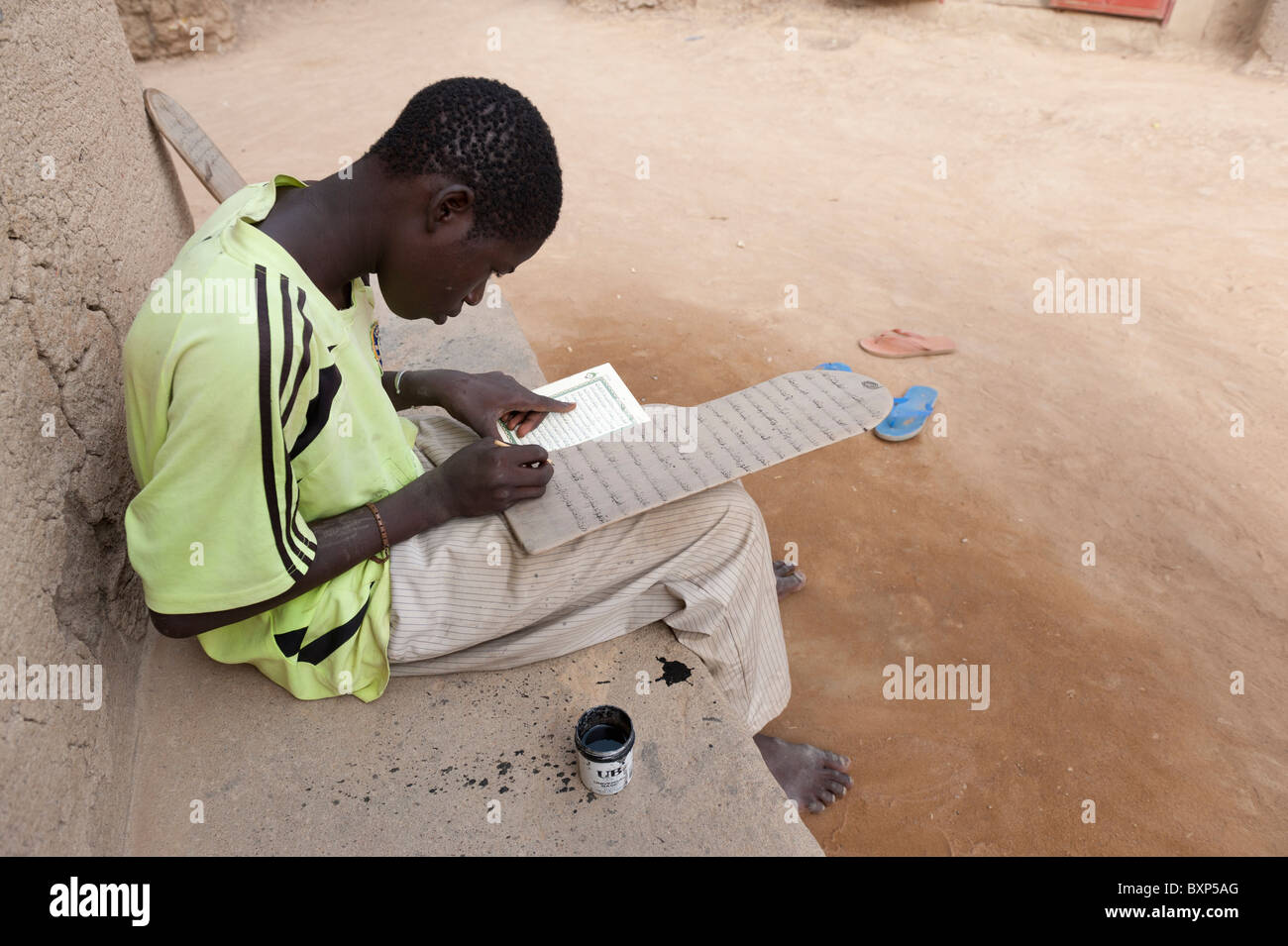 young student copying texts from the Koran on  his tablet. Djenné, Mali Stock Photo