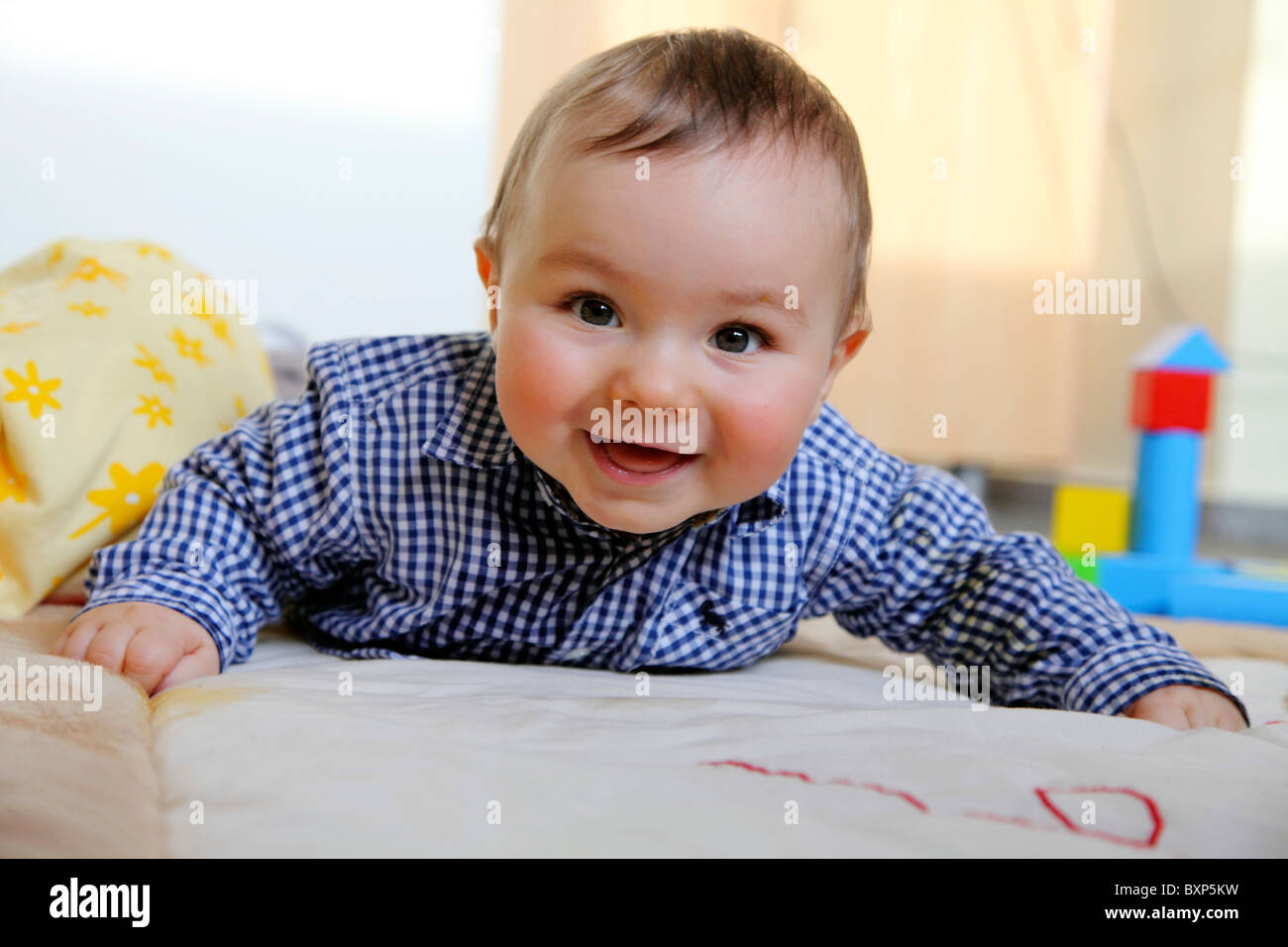 6 month old little boy laying in his children room, on a blanket