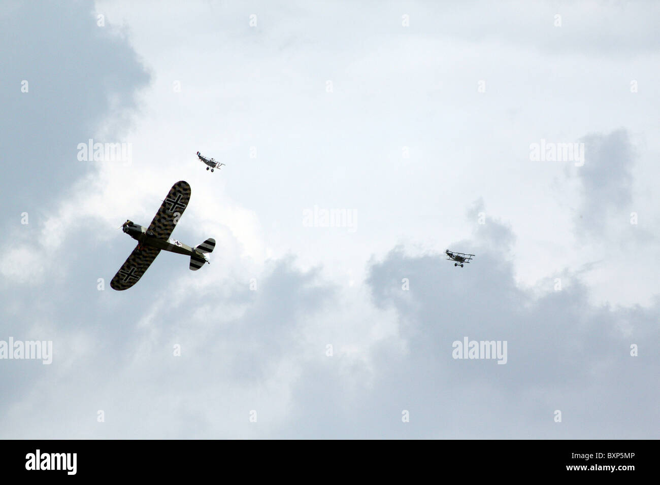 Two World War II biplanes hunt down a propeller plane in a dog fight