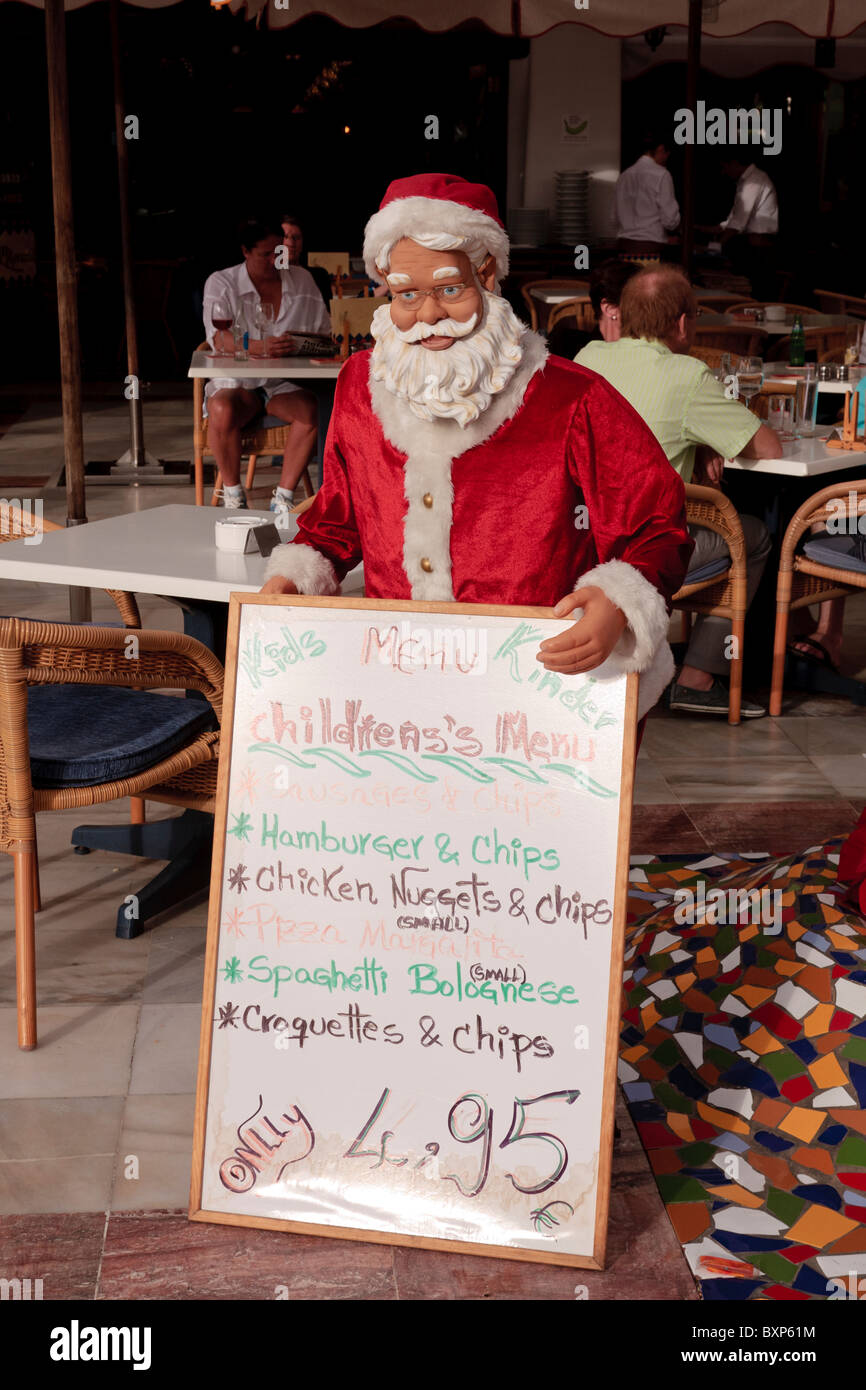 A Santa mannequin displays a menu board for a restaurant in Las Americas Tenerife Canary Islands Spain Stock Photo