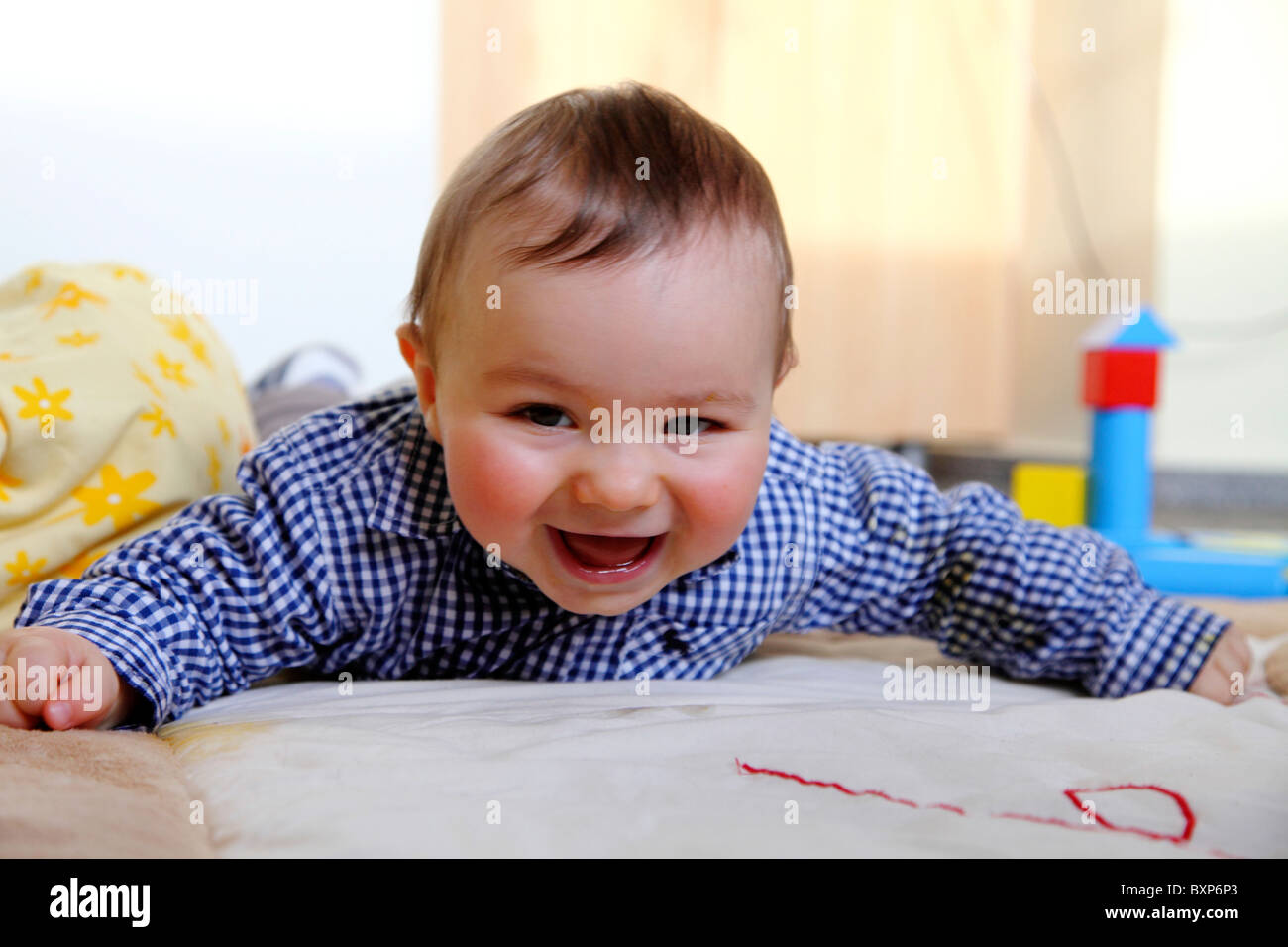 6 month old little boy laying in his children room, on a blanket