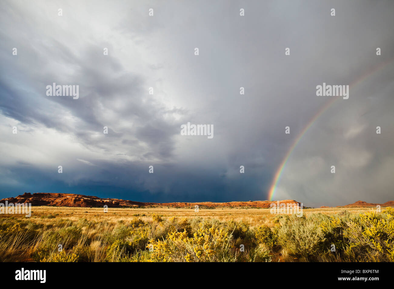 A rainbow and storm clouds over the desert of Southeast Utah, near Canyonlands National Park, USA. Stock Photo