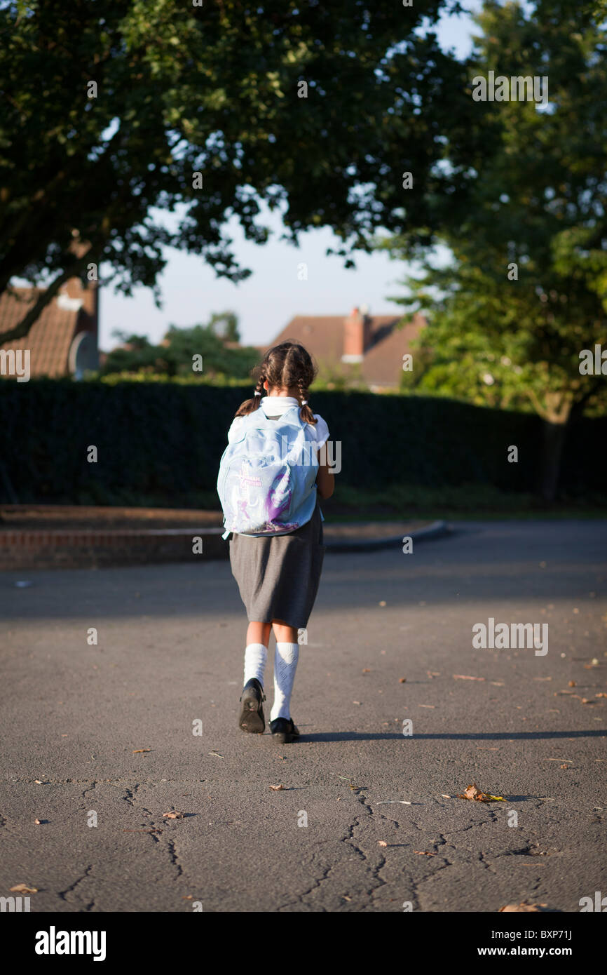 Primary schoolgirl walking to  school Stock Photo