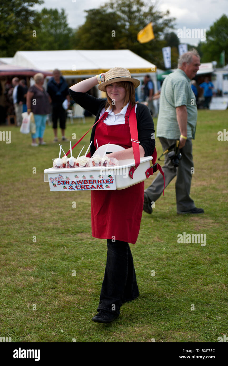 Young Woman selling Strawberries and Cream at a country show Stock Photo