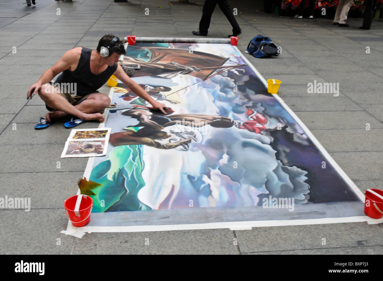 A pavement artist shows his skill in Sydney's Martin Plaza reproducing a chalk drawing of Gericault's Raft of the Medusa. Stock Photo