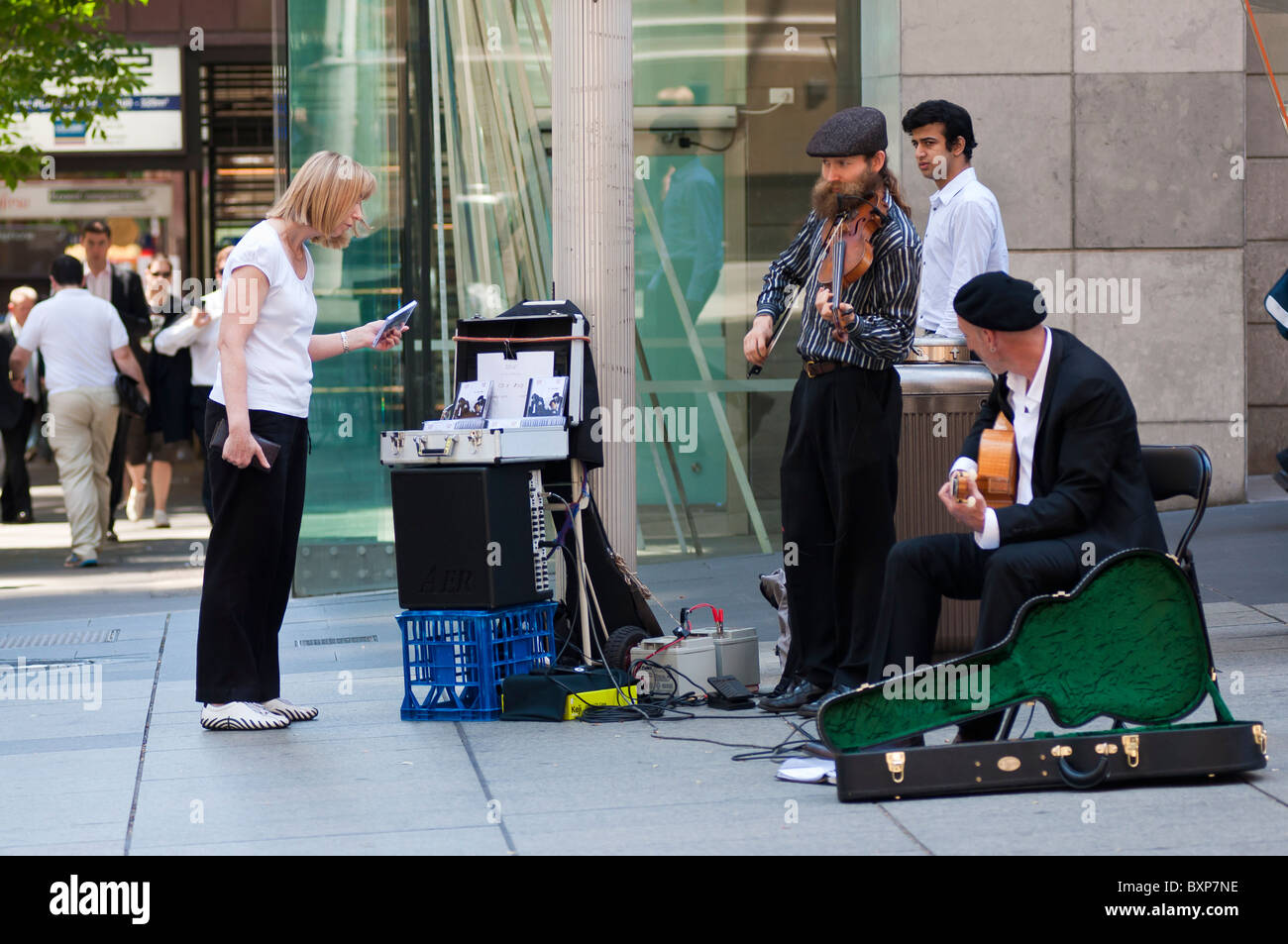 A woman looking at a buskers' CD in Martin Plaza in Sydney's CBD Stock Photo