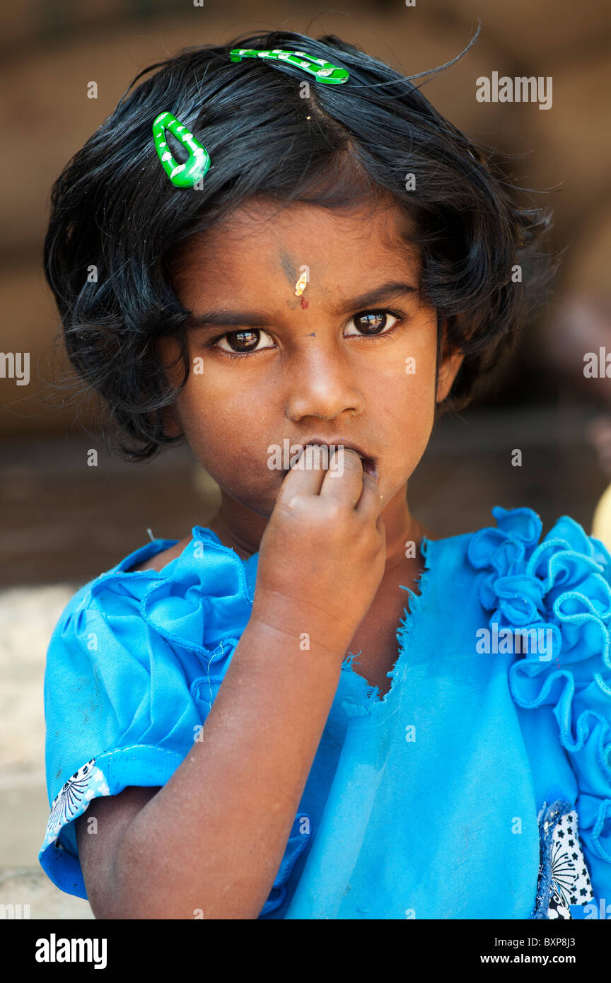 Indian village girl eating wearing a blue dress. Andhra Pradesh, India