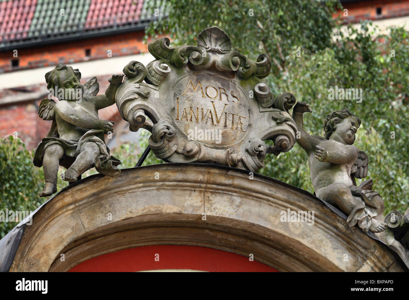Two cherubs with stone plaque on the top of the gate. Wroclaw near marketplace, Lower Silesia, Poland. Stock Photo