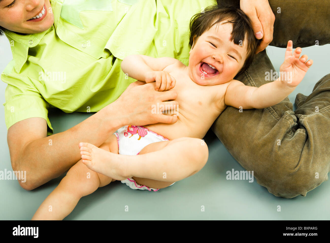 Close-up of joyful child lying on the floor and laughing from tickling Stock Photo