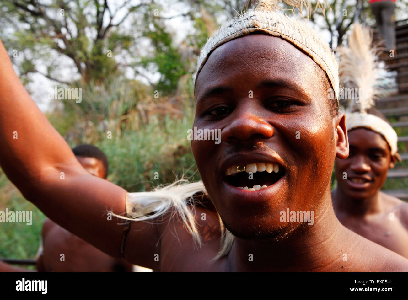 A traditional tribal singer leads dancing and singing at Victoria Falls in Zimbabwe. Stock Photo