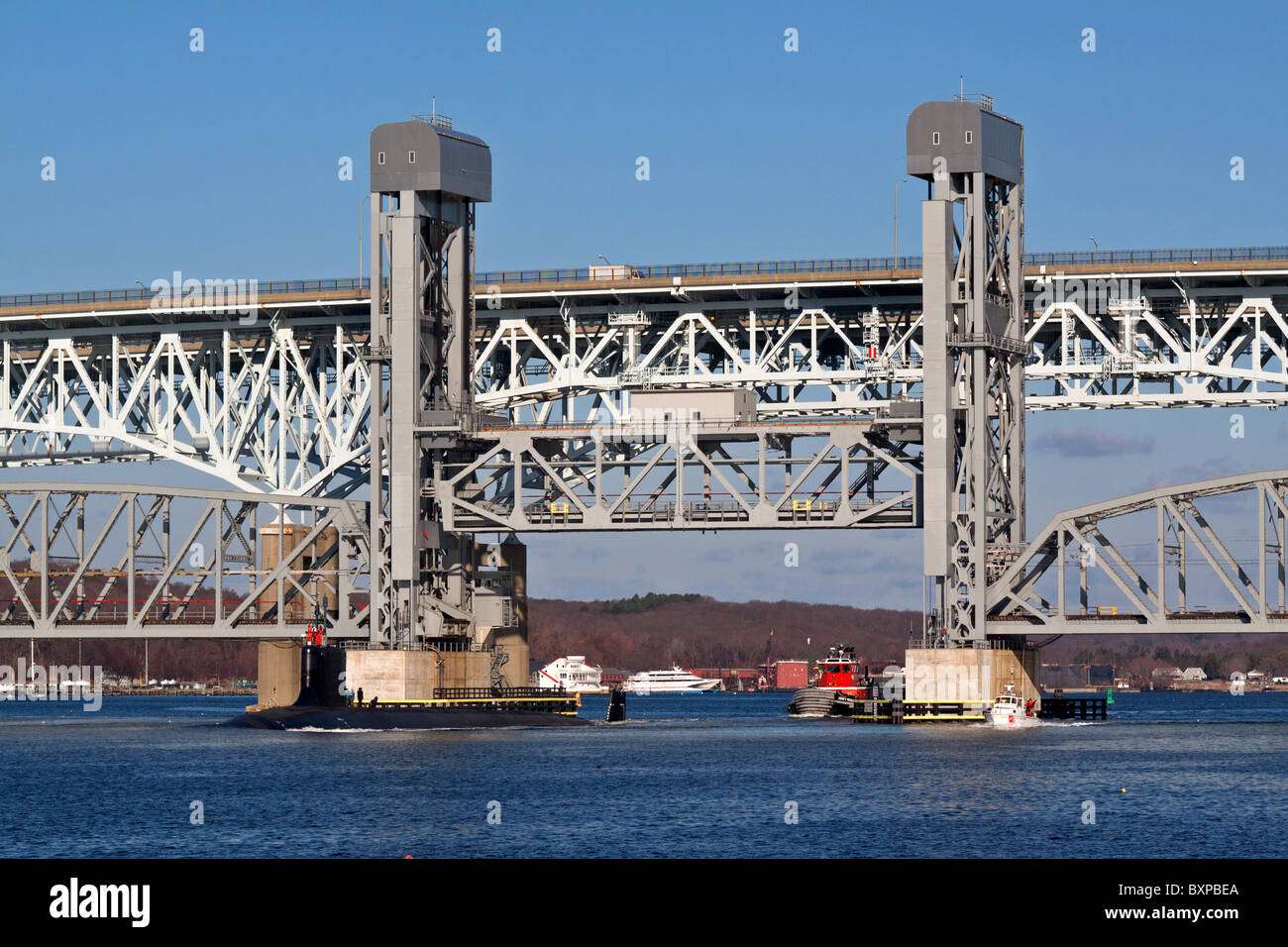 A US Navy Virginia class fast attack submarine passes through the open Amtrak Thames River Lift bridge in Connecticut Stock Photo