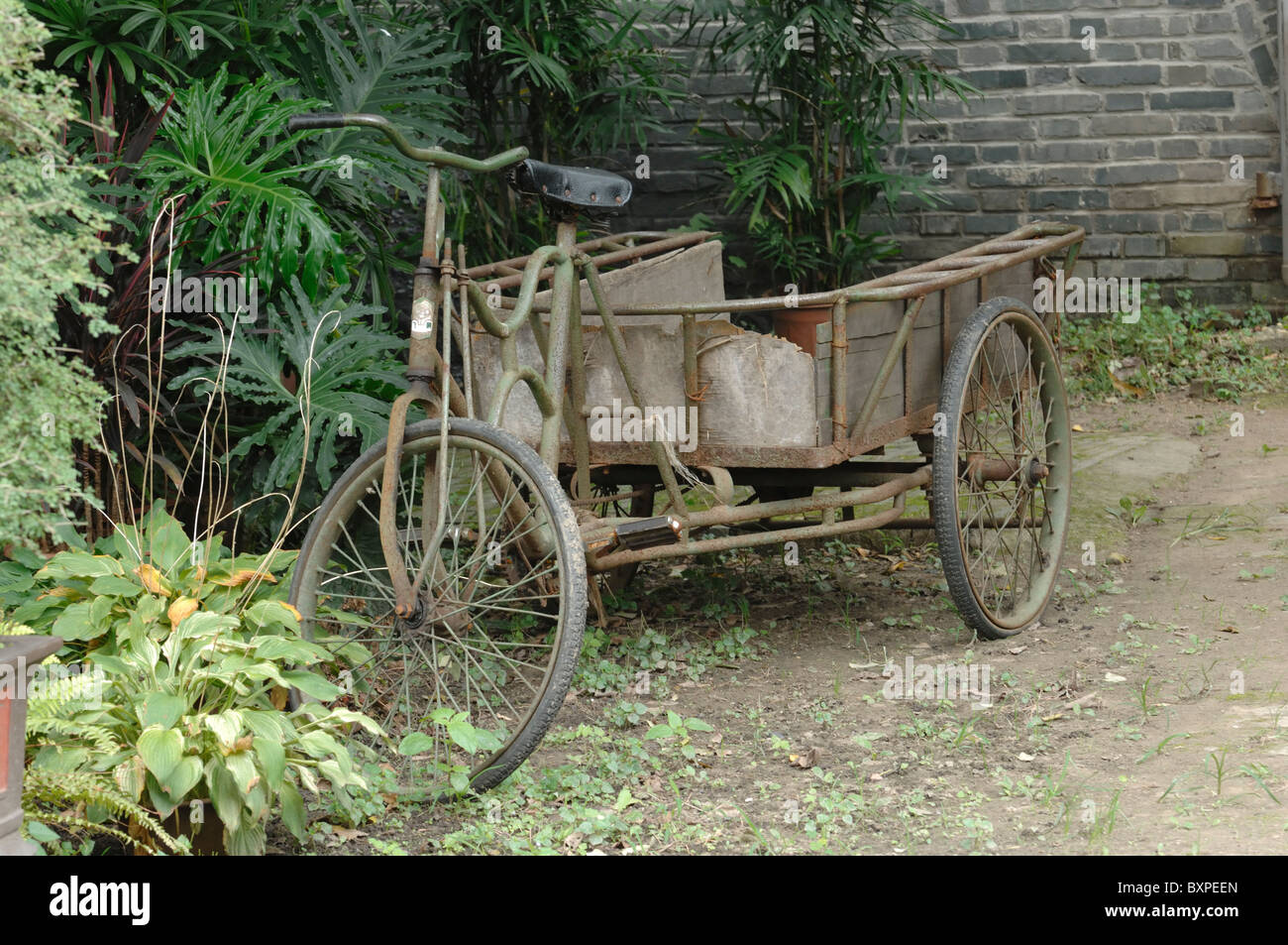 An old traditional rusty trike in Slender West Lake Park Yangzhou Jiangsu Province of China Stock Photo