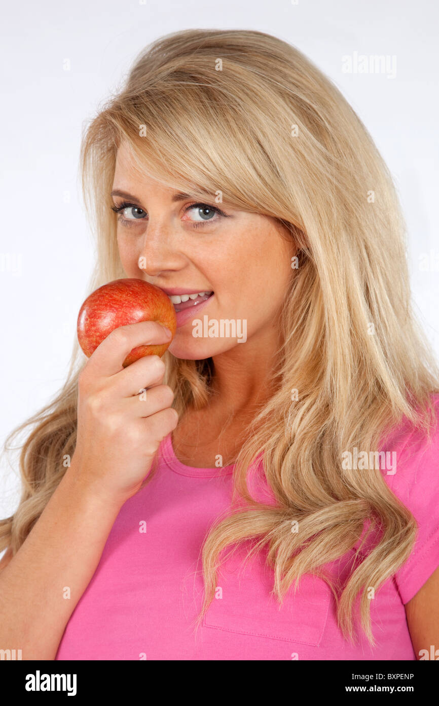 Young blond Woman eating an apple showing a healthy lifestyle Stock Photo