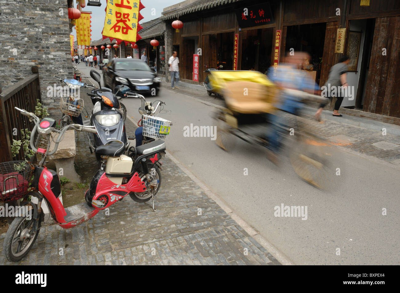 A blurred cyclist rickshaw on Dungguan Street in the Old Town area of Yangzhou Jiangsu Province of China Stock Photo