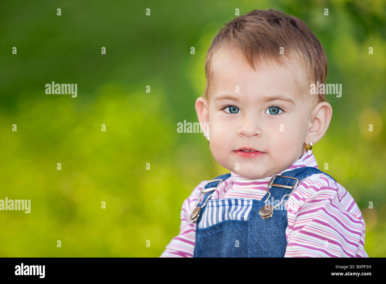 Portrait of a small baby girl wearing jeans, outdoor, looking at the camera Stock Photo Alamy