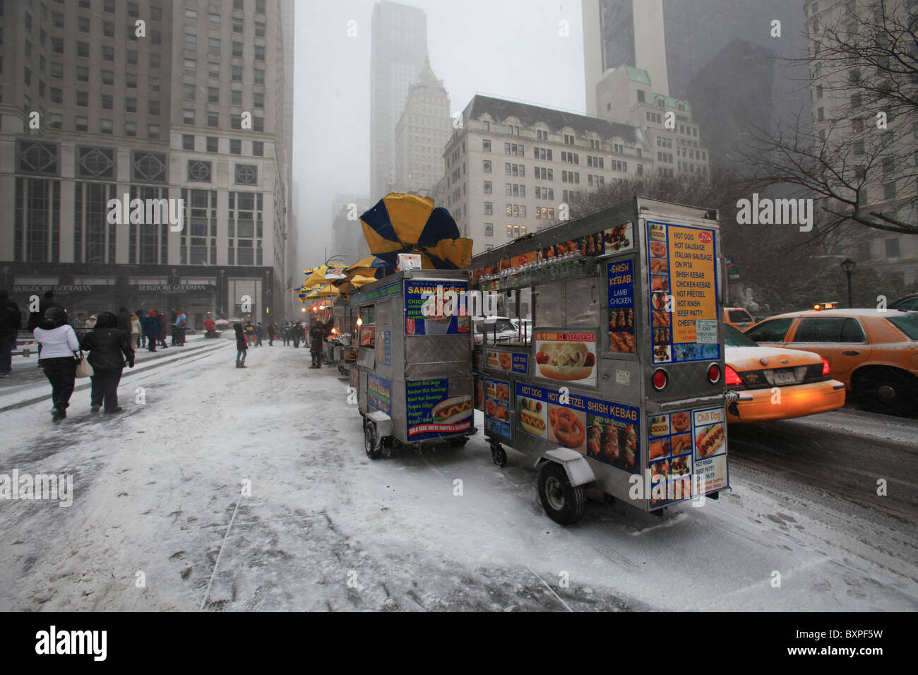 Hot dog vendors outside Apple store on Fifth ave in New York city in the great snowstorm that came down hard in Christmas 2010 Stock Photo