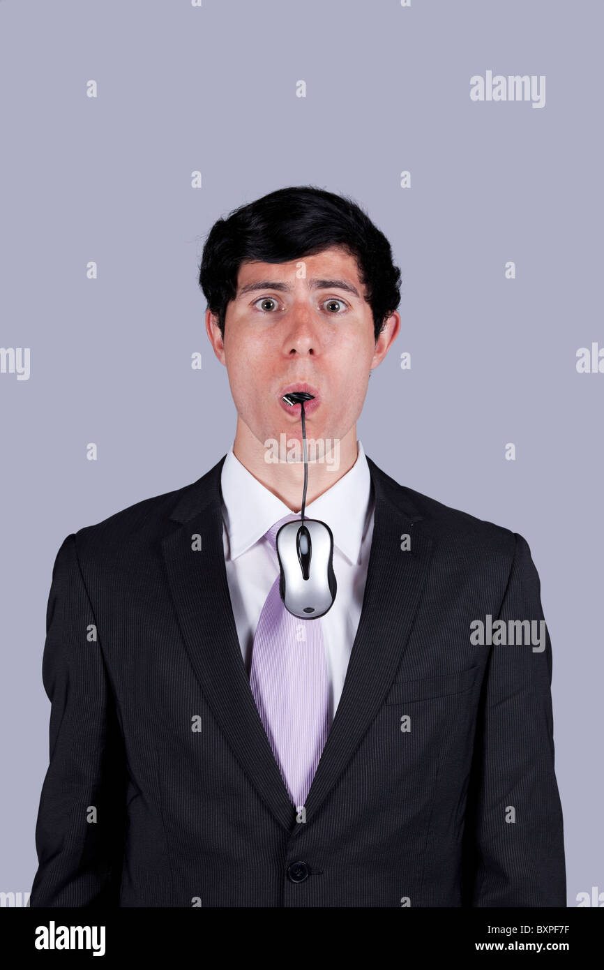 Modern businessman eating a computer mouse (isolated on gray Stock