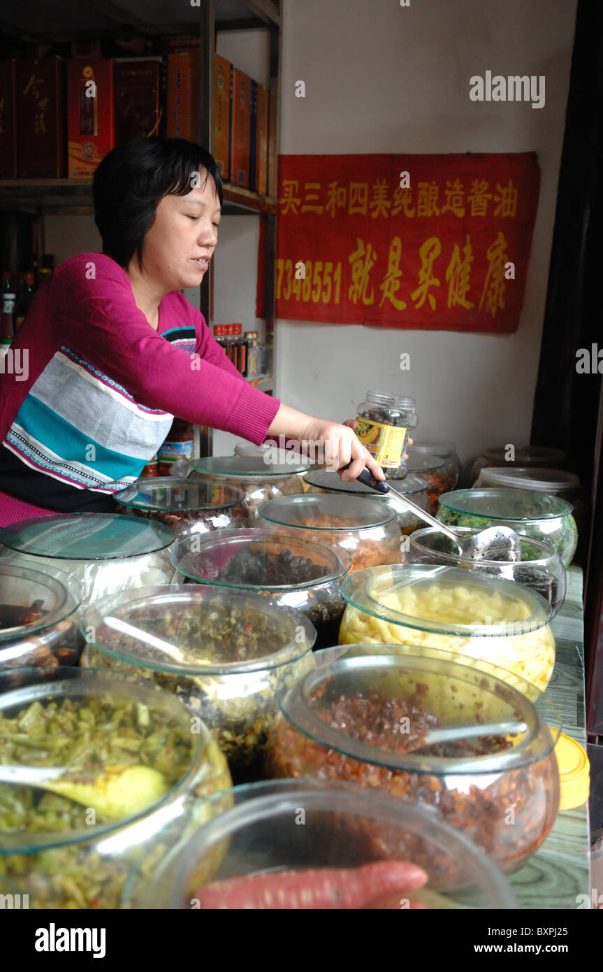 Woman working on a retail shopping market stall on the old town Dungguan Street district of Yangzhou China Stock Photo