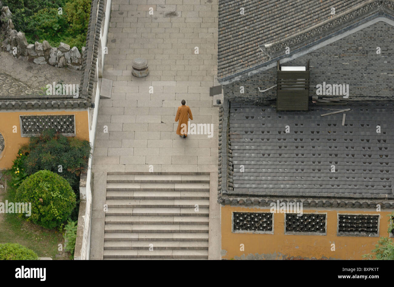 A monk walking in the gardens of Da Ming Buddhist temple in Yangzhou Jiangsu Province of China Stock Photo